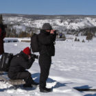 Photographers in Yellowstone National Park snap pictures in January during an eruption of Old Faithful geyser. (Ruffin Prevost/Yellowstone Gate - click to enlarge)