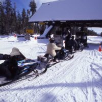 Snowmobile riders in 1998 line up at the West Gate as they wait to enter Yellowstone National Park. (Jim Peaco photo - click to enlarge)