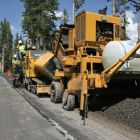 Contractors in 2009 resurface part of an 11-mile stretch of road in Yellowstone National Park between the Lewis River Bridge and the park's South Entrance. Yellowstone road closures are planned as part of summer 2012 construction projects around the Tower and Canyon areas. (NPS photo by Jim Peaco)