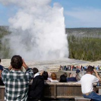 Visitors to Yellowstone National Park watch Old Faithful Geyser erupt from the deck of the Old Faithful Inn. (Yellowstone Gate file photo/Ruffin Prevost)