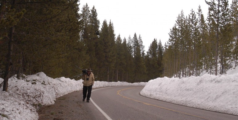 Nature photographer Gene Grove carries his camera and tripod along the road bordering the Yellowstone River. 