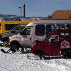 Snow coaches operated by private tour guide companies are parked near Old Fiathful Geyser in Yellowstone National Park. (Ruffin Prevost/Yellowstone Gate - click to enlarge)