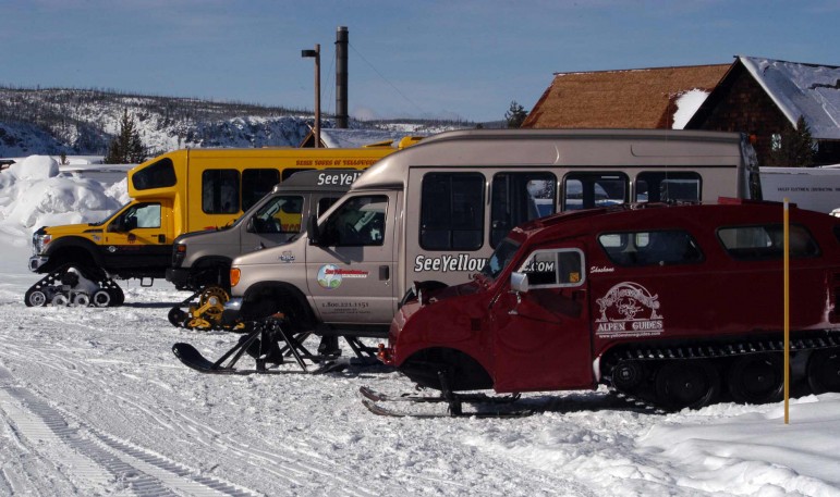 Snow coaches operated by private tour guide companies are parked near Old Fiathful Geyser in Yellowstone National Park. (Ruffin Prevost/Yellowstone Gate - click to enlarge)