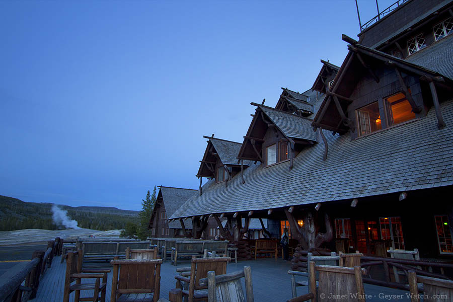 A guest steals a quiet moment with Old Faithful geyser in the distance while on the second-floor observation deck at the Old Faithful Inn in Yellowstone National Park. (Janet White/Geyser Watch - click to enlare)