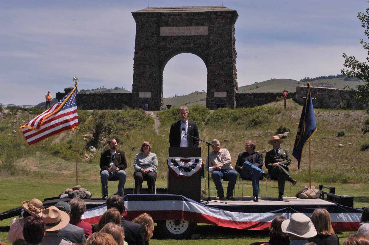 Bill Berg, president of the Greater Gardiner Community Council, speaks in front of the Roosevelt Arch during the Gardiner Gateway Project kickoff event in summer 2012. Joining him on stage were, from left, Daniel Bierschwale, President, Gardiner Chamber of Commerce; Clara Conner, Division Engineer, Western Federal Lands Highway Division; Marty Malone, Commissioner, Park County, Mont.; Brian Schweitzer, Governor of Montana; and Dan Wenk, Superintenden of Yellowstone National Park. (Ruffin Prevost/Yellowstone Gate - click to enlarge) Bill Berg, president of the Greater Gardiner Community Council, speaks in front of the Roosevelt Arch during the Gardiner Gateway Project kickoff event in summer 2012. Joining him on stage were, from left, Daniel Bierschwale, President, Gardiner Chamber of Commerce; Clara Conner, Division Engineer, Western Federal Lands Highway Division; Marty Malone, Commissioner, Park County, Mont.; Brian Schweitzer, Governor of Montana; and Dan Wenk, Superintenden of Yellowstone National Park. (Ruffin Prevost/Yellowstone Gate - click to enlarge)
