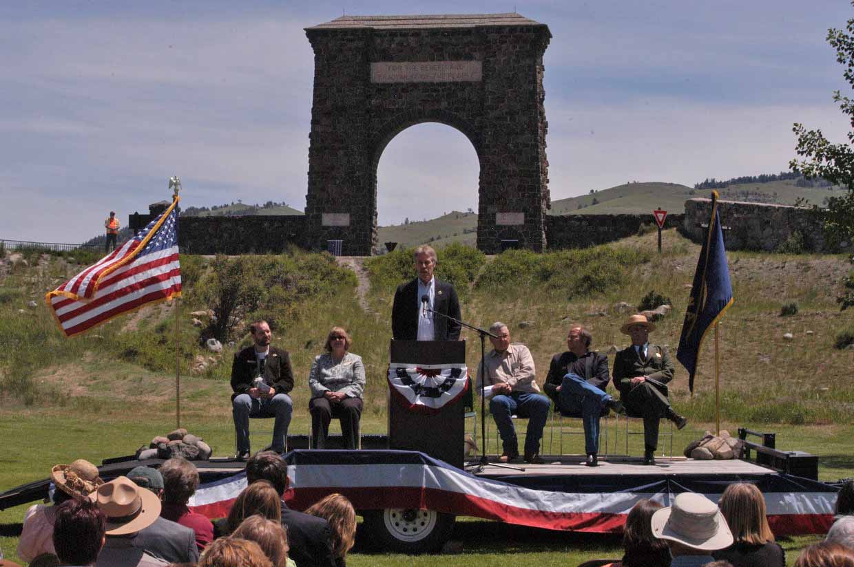 Bill Berg, president of the Greater Gardiner Community Council, speaks in front of the Roosevelt Arch during the Gardiner Gateway Project kickoff event in summer 2012. Joining him on stage were, from left, Daniel Bierschwale, President, Gardiner Chamber of Commerce; Clara Conner, Division Engineer, Western Federal Lands Highway Division; Marty Malone, Commissioner, Park County, Mont.; Brian Schweitzer, Governor of Montana; and Dan Wenk, Superintenden of Yellowstone National Park.  (Ruffin Prevost/Yellowstone Gate - click to enlarge)