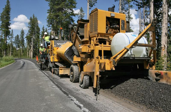 Contractors in 2009 resurface part of an 11-mile stretch of road in Yellowstone National Park between the Lewis River Bridge and the park's South Entrance. Yellowstone road closures are planned as part of summer 2012 construction projects around the Tower and Canyon areas. (NPS photo by Jim Peaco)