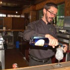 Topher Reimers tends bar at the Bear Pit in the Old Faithful Inn in Yellowstone National Park. Reimers had worked for six years in the park when this photo was taken in June 2006. (Ruffin Prevost/Yellowstone Gate file photo)