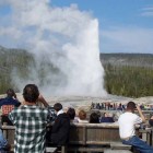 Visitors to Yellowstone National Park watch Old Faithful geyser erupt. (Ruffin Prevost/Yellowstone Gate)