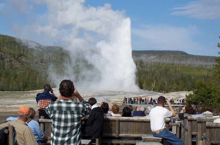 Visitors to Yellowstone National Park watch Old Faithful geyser erupt. (Ruffin Prevost/Yellowstone Gate)