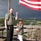 Nathan Bartlett, 8, helps Old Faithful Inn bellman Ed Nabors take down the American flag atop the hotel during a 2012 summer trip to Yellowstone National Park. (NPS photo by Dan Hottle - click to enlarge)