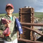 Nathan Bartlett, 8, holds two flags given to him by Xanterra Parks & Resorts atop the Old Faithful Inn in Yellowstone National Park. (NPS photo by Dan Hottle - click to enlarge)