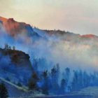 Smoke and sunlight create deep, surreal colors during the 2008 Gunbarrel Fire, which burned along the eastern boundary of Yellowstone National Park.