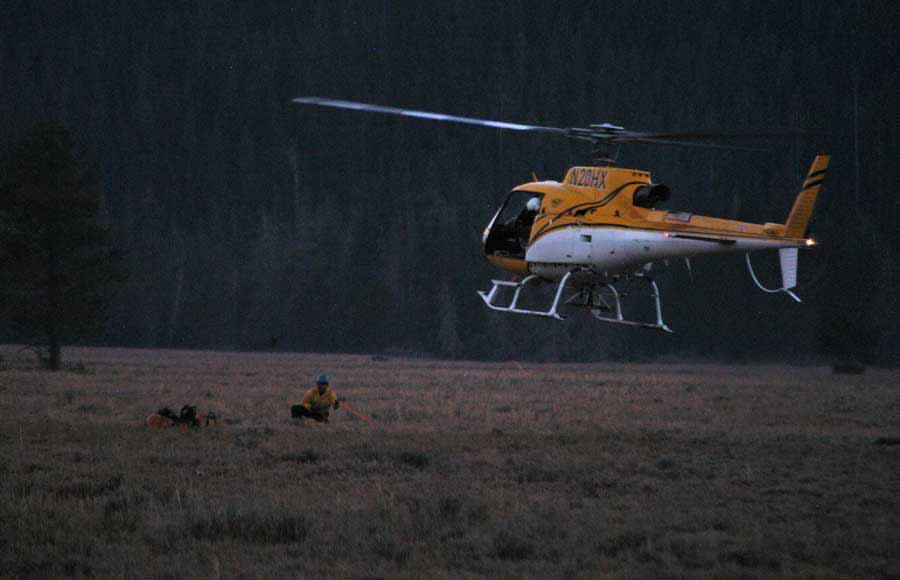 A search and rescue helicopter lands at the Jenny Lake rescue cache near Lupine Meadows in Grand Teton National Park on Saturday after completing a short-haul extraction of an imperiled climber from the Teewinot Mountain area. (Yellowstone Gate/Ruffin Prevost - click to enlarge)