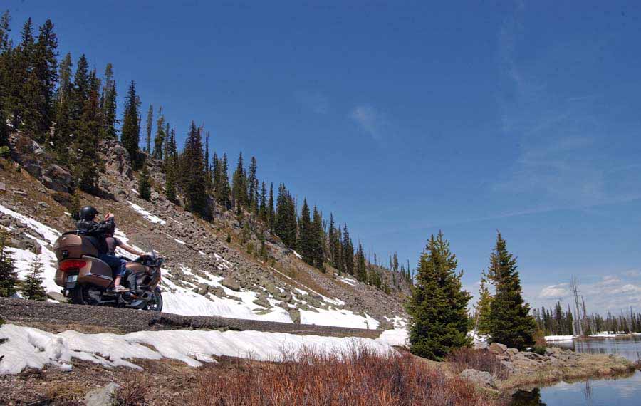 A motorcycle passes between the base of Talus Slope and the Lewis River in Yellowstone National Park. (Yellowstone Gate file photo/Ruffin Prevost - click to enlarge)