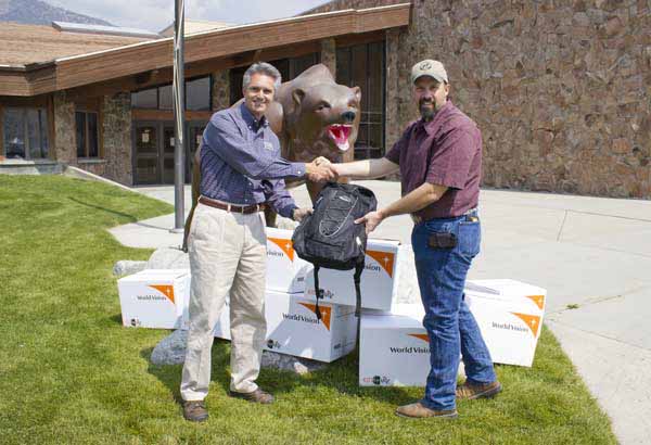 Jim McCaleb, left, general manager of Xanterra Parks & Resorts' Yellowstone operations, presents packpacks full of school supplies in Gardiner, Mont. (courtesy photo)