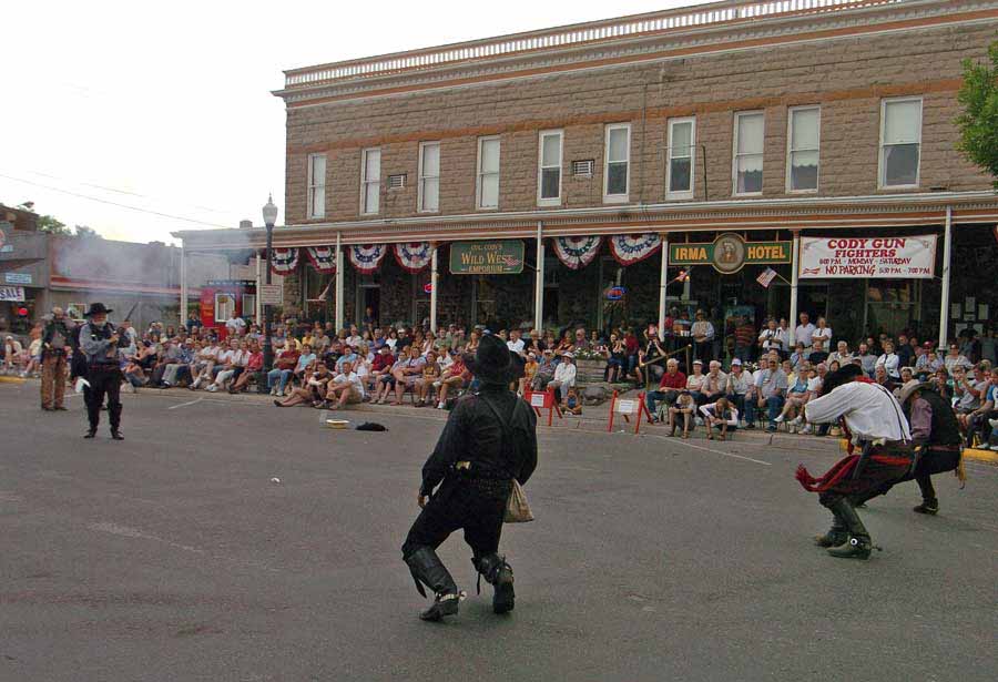 A crowd watches from the porch of the Irma Hotel in Cody as three villains are shot in a mock gunfight. (Ruffin Prevost - Yellowstone Gate file photo - click to enlarge)