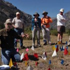 Archaeologist Larry Todd, kneeling, shows dozens of artifacts marked with small flags in the Shoshone National Forest during a July field trip sponsored by the Greater Yellowstone Coalition. (Ruffin Prevost/Yellowstone Gate - click to enlarge)