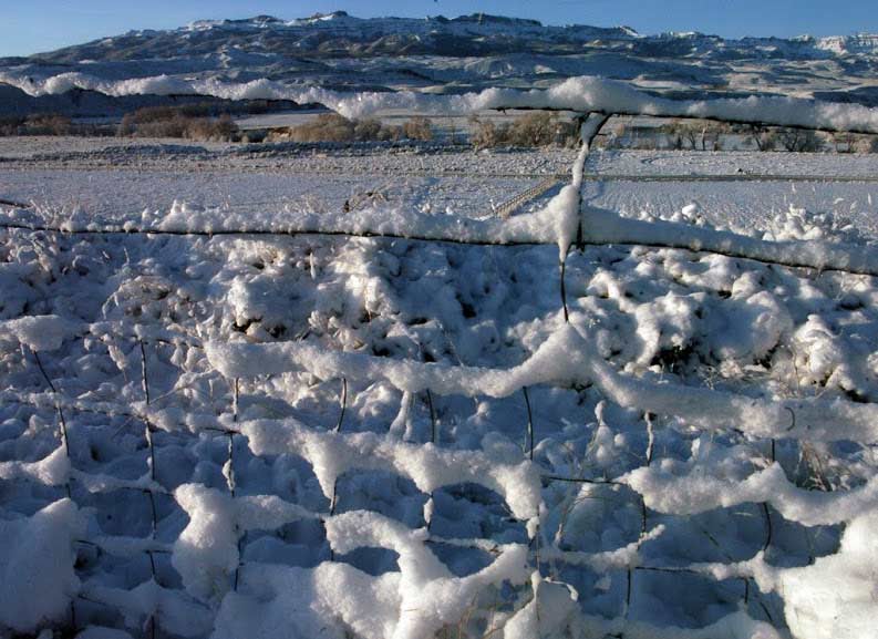 Snow collects on a fence near Sheep Mountain southeast of Yellowstone National Park. (Ruffin Prevost/Yellowstone Gate)