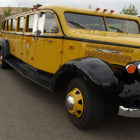 Park County Travel Council Marketing Director Claudia Wade, right, chats with visitors to the Buffalo Bill Historical Center in Cody, Wyo. about a refurbished 1936 tour bus that is used for commercial tours in Yellowstone National Park. (Yellowstone Gate file photo/Ruffin Prevost)