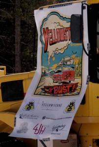 A promotional banner hangs on a Wyoming Department of Transportation snowplow clearing snow Monday along the East Entrance Road in Yellowstone National Park. (Ruffin Prevost/Yellowstone Gate - click to enlarge)