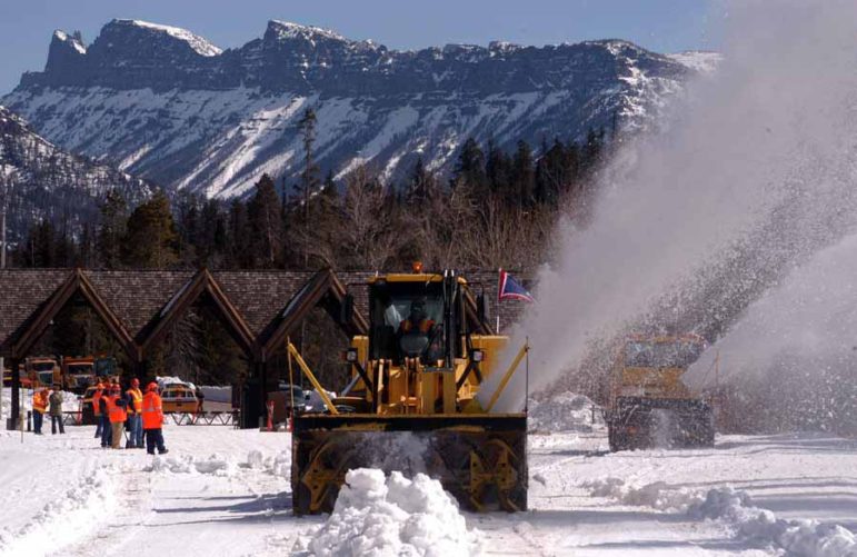 Workers look on as two rotary snowplows enter Yellowstone National Park on Monday to begin removing snow along the East Entrance Road. (Ruffin Prevost/Yellowstone Gate - click to enlarge)