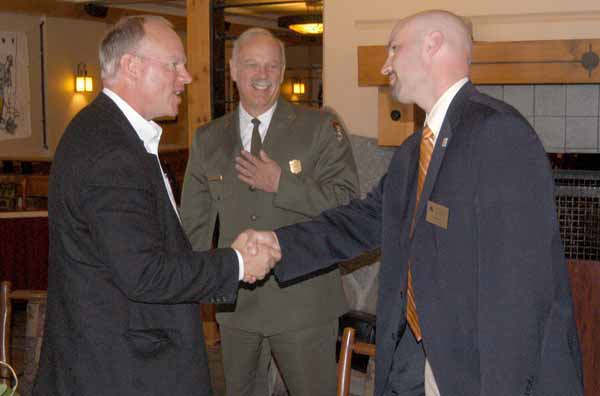 Wyoming Gov. Matt Mead, left, shakes hands with Cody Country Chamber of Commerce Executive Director Scott Balyo as Yellowstone National Park Superintendent Dan Wenk looks on. The men were among those attending a luncheon Friday at Old Faithful Lodge to mark the end of National Travel and Tourism Week and the successulf cooperative effort to plow park roads. (Ruffin Prevost/Yellowstone Gate)
