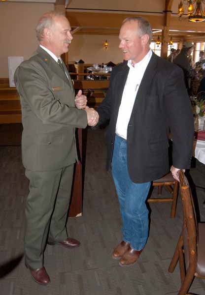 Yellowstone National Park Superintendent Dan Wenk, left, shakes hands with Wyoming Gov. Matt Mead on Friday during a luncheon at Old Faithful Lodge to mark the end of National Travel and Tourism Week and the successulf cooperative effort to plow park roads. (Ruffin Prevost/Yellowstone Gate)