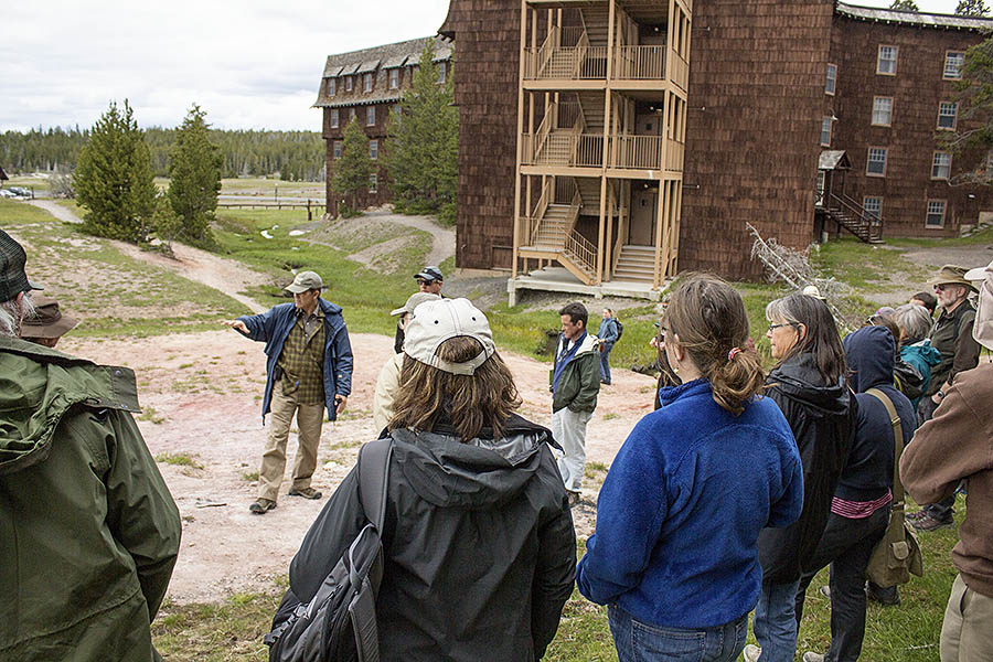 Yellowstone National Park geologist Hank Heasler gestures while explaining to a group of science conference attendees some of the complications of building around the Old Faithful area. (Janet White/GeyserWatch.com)