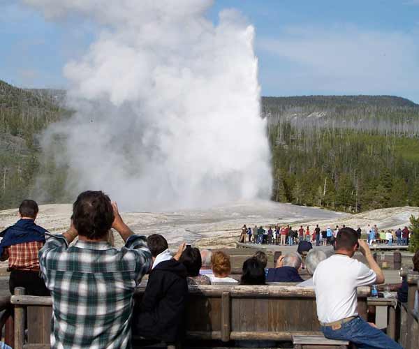 Visitors to Yellowstone National Park watch Old Faithful Geyser erupt from the deck of the Old Faithful Inn. (Yellowstone Gate file photo/Ruffin Prevost)