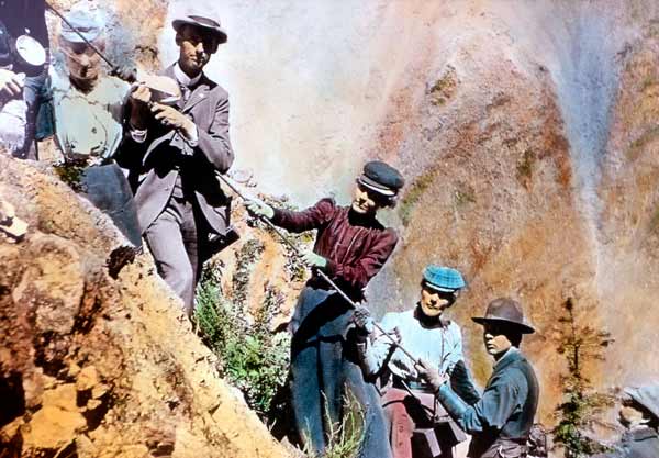 A colorized photo shows early Yellowstone National Park visitors climbing along Uncle Tom's Trail. (Yellowstone Digital Slide File)