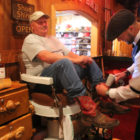 Tim Tetley works on Gordon Little’s boots at Tetley’s shoe-shine stand in the Cowboy Bar in Jackson, Wyo., south of Grand Teton National Park.