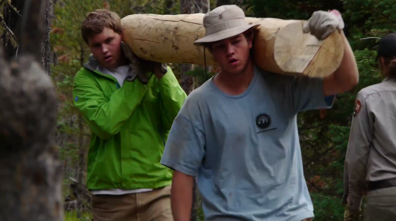 Participants in the Grand Teton National Park Youth Conservation Program move a log during a trail project.