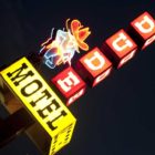 The Dude Motel sign lights up the night sky in West Yellowstone, Mont., where tourism has dropped sharply since the government shutdown closed Yellowstone National Park.