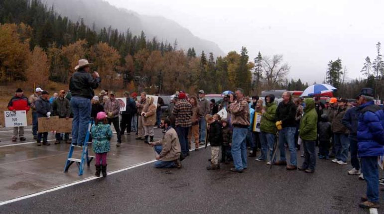 Protest organizer Rick Satterthwaite of Cody, Wyo. stands on a ladder as he speaks to a crowd of approximately 75 who gathered at the East Gate to Yellowstone National Park on Sunday to demand a solution to the federal government shutdown that has closed national parks nationwide. 