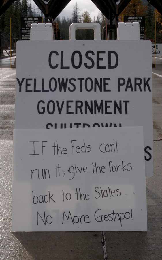 A handmade sign left by a protestor leans against a closure sign Sunday at the East Gate to Yellowstone National Park. Yellowstone was established as a the world's first national park in 1872, more than 18 years before Wyoming became a state. 
