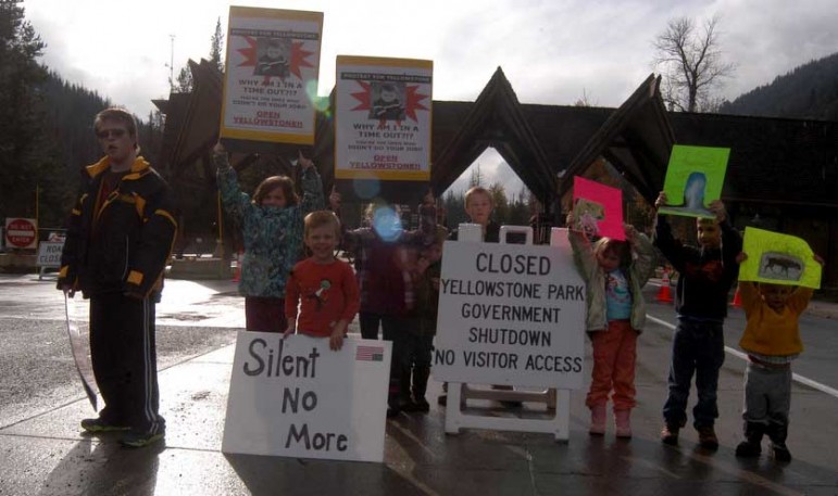 A group of kids hold up protest signs Sunday at the East Gate to Yellowstone National Park. 