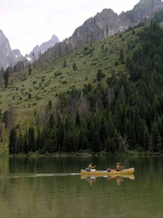 Boaters paddle a canoe on String Lake in Grand Teton National Park.