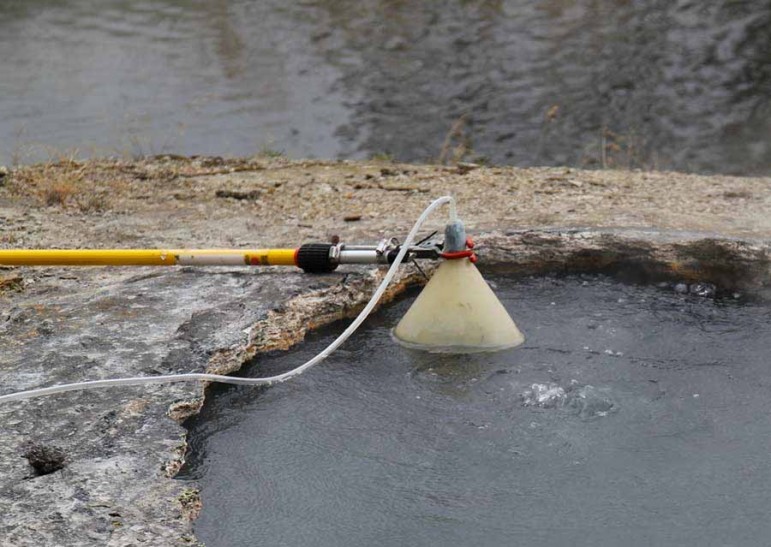 A funnel placed over a pool at Shoshone Geyser Basin in Yellowstone National Park gathers gas samples as part of a study to learn more about the processes that drive the park's thermal features.