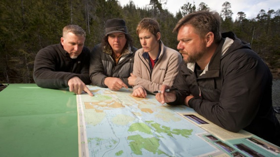 From left, Cliff Barackman, James Fay, Ranae Holland and Matt Moneymaker consult a map during an episode of “Finding Bigfoot.”