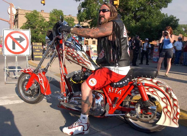 A Hells Angels member from Arizona checks traffic  before pulling onto Sheridan Avenue during the group's 2006 World Run in Cody, Wyo.