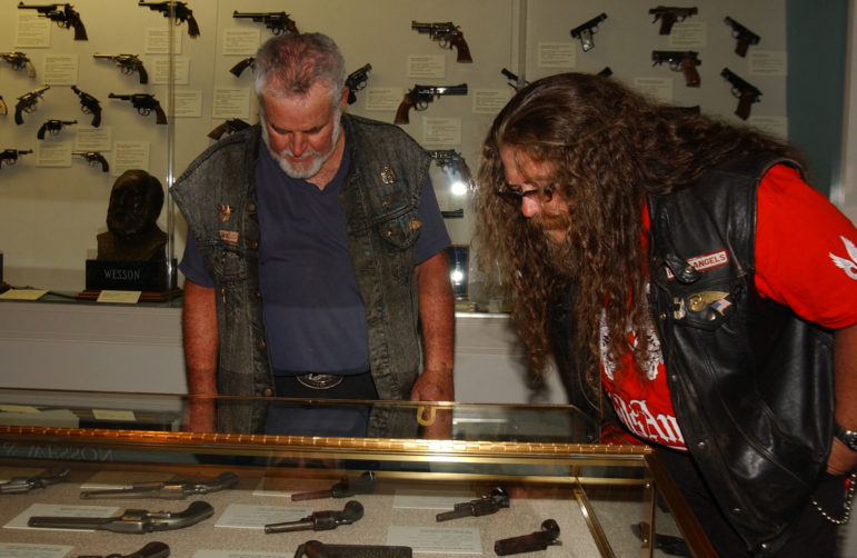 Two Hells Angels motorcycle club members from California survey a few of the thousands of firearms on display at the Cody Firearms Museum in the Buffalo Bill Center of the West during the group's 2006 World Run in Cody, Wyo.