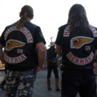 A Hells Angels motorcycle club member from Austria and one from Germany watch a mock gunfight at the Irma Hotel in Cody, Wyo. during the group's 2006 World Run this week.