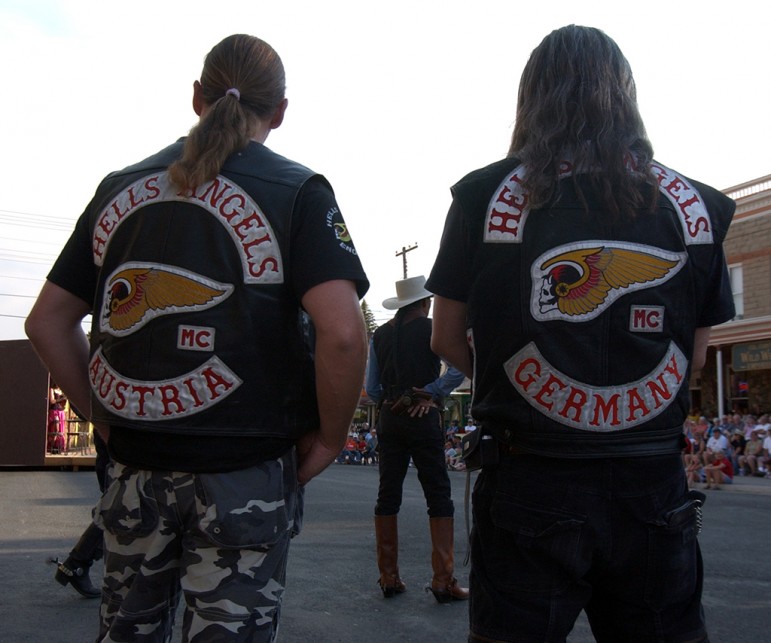A Hells Angels motorcycle club member from Austria and one from Germany watch a mock gunfight at the Irma Hotel in Cody, Wyo. during the group's 2006 World Run this week.