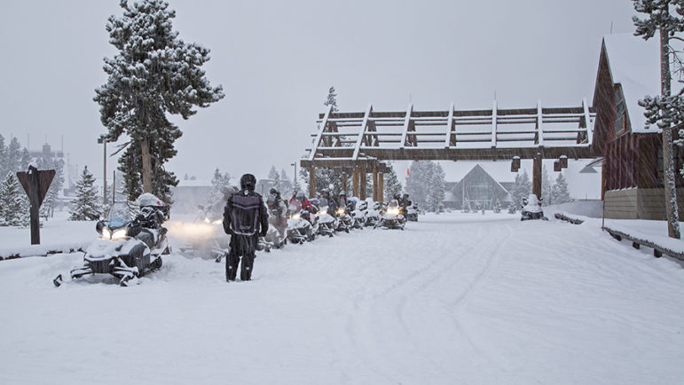 Riders line up their snowmobiles outside the Old Faithful Snow Lodge in Yellowstone National Park.