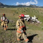 Emergency personnel walk past the wreckage of a crashed airplane Monday after the injured pilot was transported for medical care.