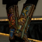 A model shows off a pair of boots designed by Scott Wayne Emmerich of Tres Outlaws during the Cody High Style Fashion show on Wednesday in Cody, Wyo.