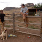 P.J. Schneider, left, and dog dexter take a break while installing an electric fence last month with Russ Talmo. Defenders of wildilfe helped Schneider with cost-sharing and tehnical expertise on the project at a ranch southwest of Cody, Wyo. where chickens and goats could attract grizzly bears.