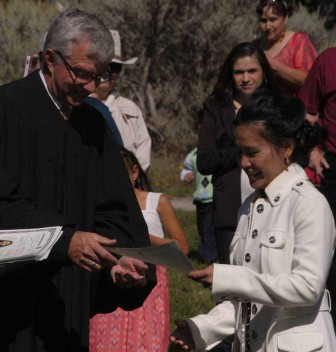 Grace Dolbear of Colstrip, Mont. accepts her certificate of citizenship from U.S. Magistrate Judge for the District of Wyoming Mark Carman during a Sept. 3 naturalization ceremony at Mammoth Hot Springs in Yellowstone National Park.