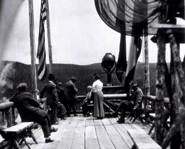 Visitors take in the view from atop the Old Faithful Inn in this undated Yellowstone National Park archival photo, likely from around 1910.